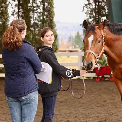 Deerfield's head coach Katie with youth riding student